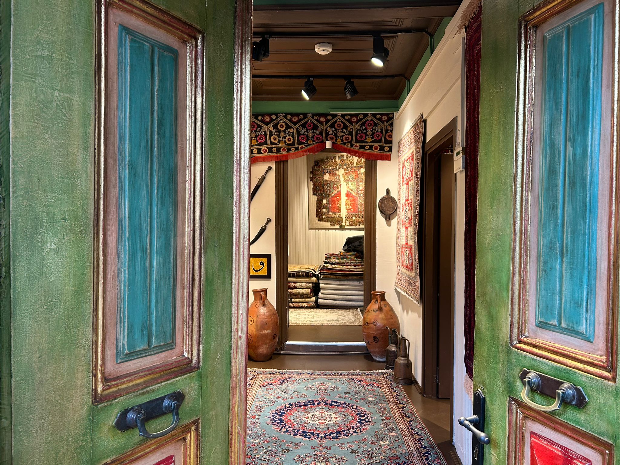 Painted doors opening onto the Gordes rooms, rugs lining the corridor
